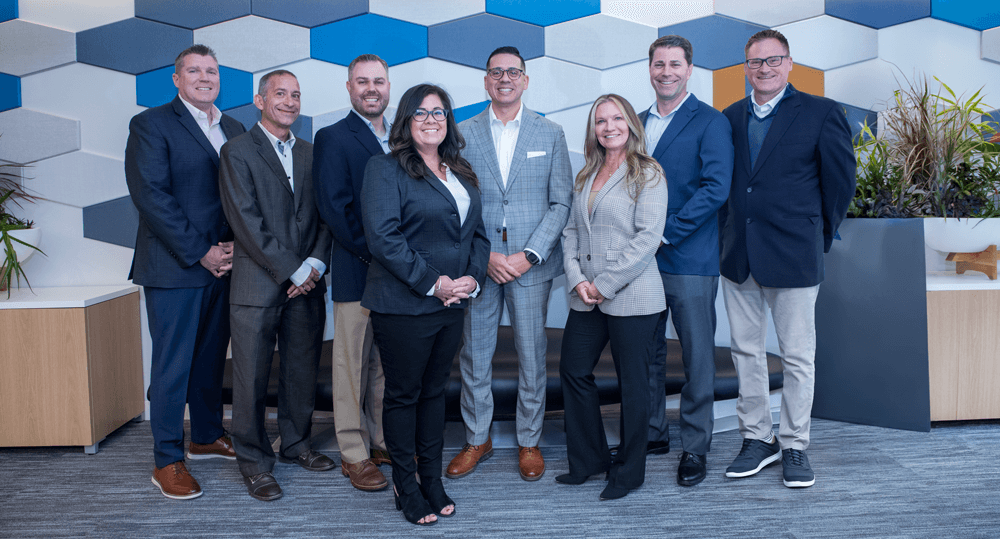 Positive Physicians leadership team standing together at the Positive headquarters in City Center, Philadelphia. From left to right: Brian Durkin, Joe Stichler, Blake Petty, Annie Matincheck, Michael G. Roque (CEO), Shelly Ursini, Cobie Buchman, and Chris Buchs.