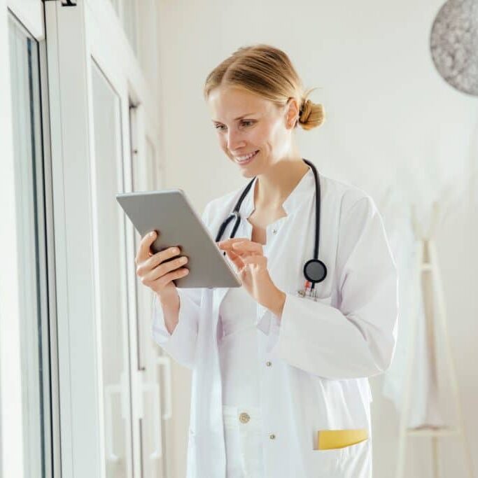 smiling female doctor using digital tablet